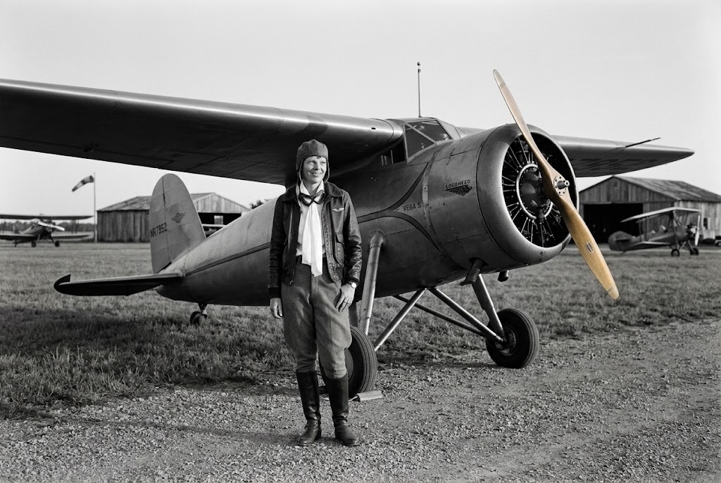 Amelia Earhart beside a vintage airplane
